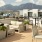 a patio with chairs and tables and a view of a city